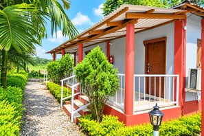 A red building with a porch, steps, and a door. - Khamar Bari (Mal)