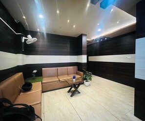 Ein stilvoller Wartebereich mit einer Couch, einem kleinen Tisch und einer Zimmerpflanze.