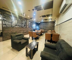 A modern lounge area with sofas, tables, and a decorative wall.