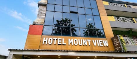 A hotel with a modern facade, large windows, and a sign reading 'HOTEL MOUNT VIEW'.
