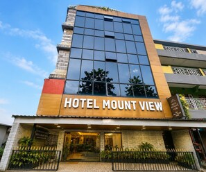 Ein Hotel mit moderner Fassade, großen Fenstern und einem Schild mit der Aufschrift 'HOTEL MOUNT VIEW'.