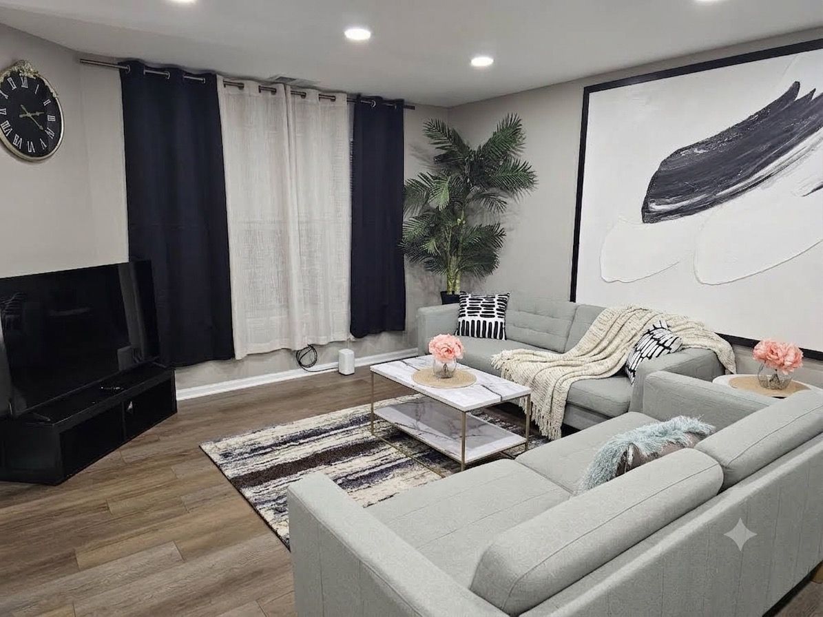 Una sala de estar moderna con un sofá, una mesa de centro y un cuadro grande en la pared.