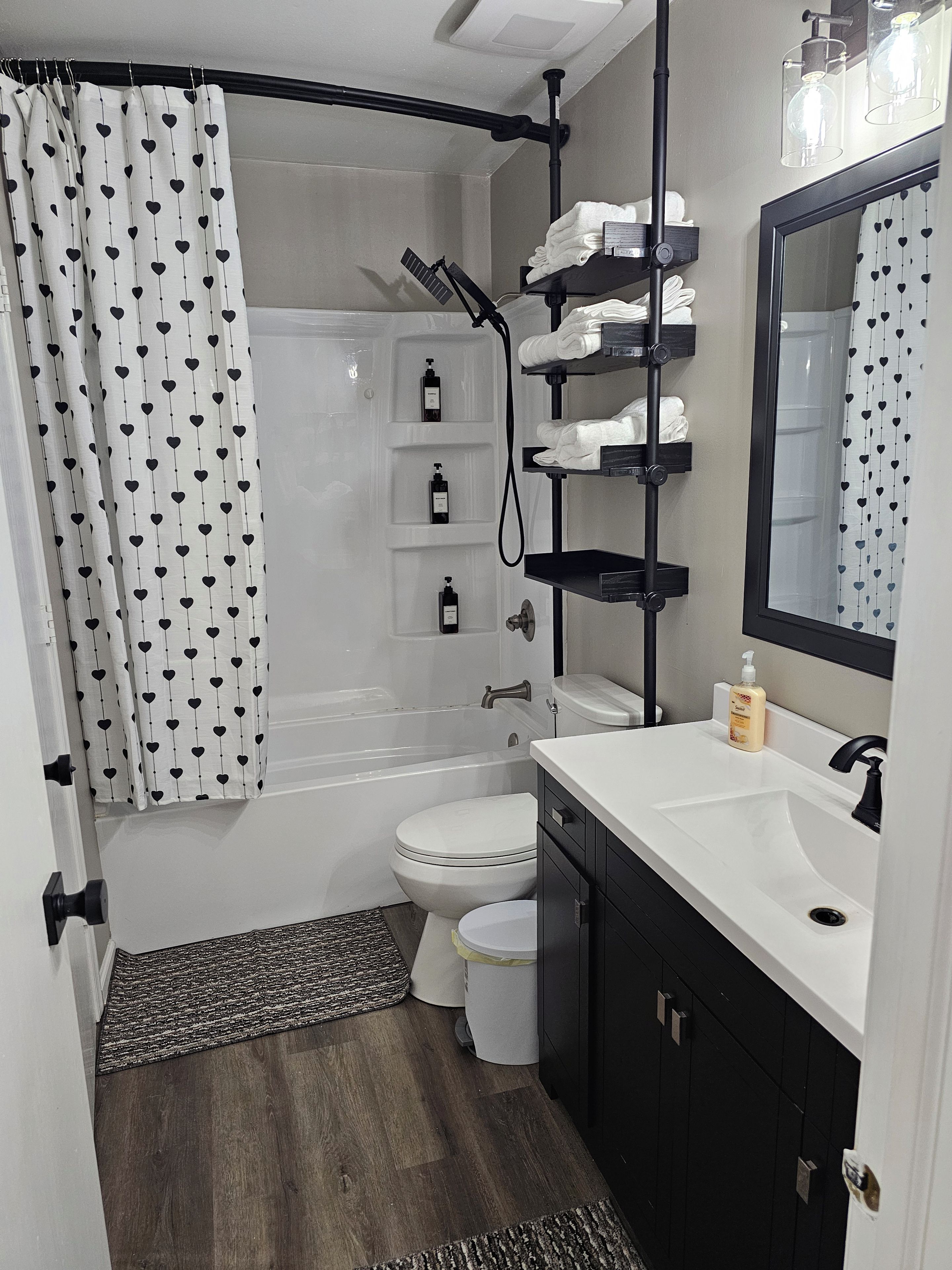 A bathroom with a bathtub, toilet, and a sink with a mirror.