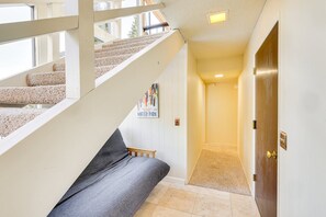 Eine Treppe führt zu einer Empfangshalle mit Teppichboden, einer hölzernen Bank und einer Tür mit Messingknauf.