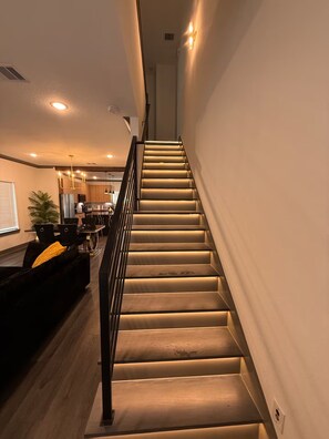 A staircase with a handrail, leading to an upper floor. - The Luxury Den Just Mins from Downtown Houston (Houston)