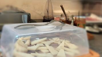 Un contenitore per alimenti con coperchio trasparente, posato su un tagliere di legno.