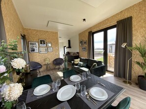 A dining area with a table set for four, chairs, and a view of the outdoors. - Holiday Home in Kampen With Swimming Pool (Oldebroek)
