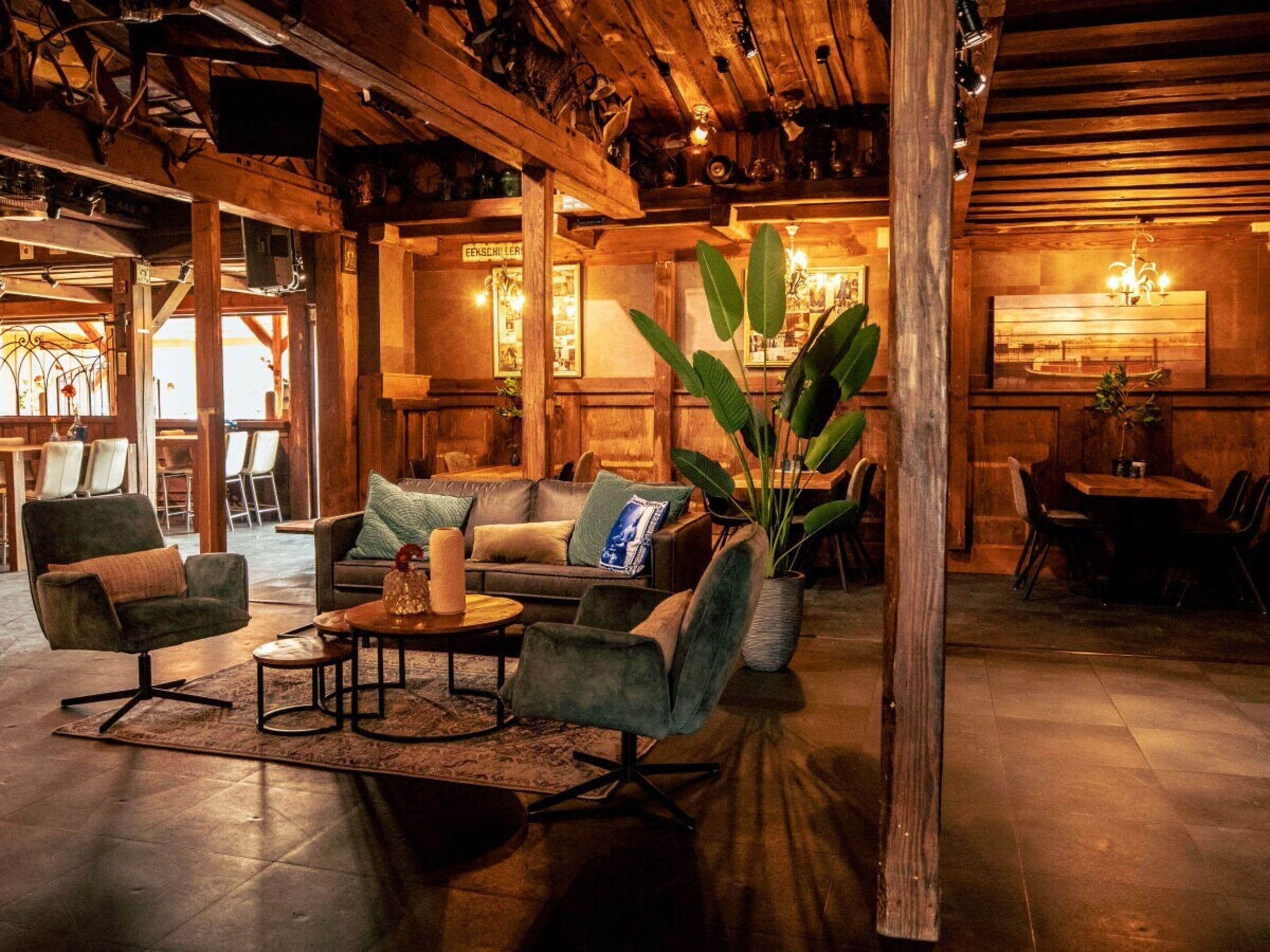 A cozy lounge area with a sofa, chairs, a coffee table, and a large plant.