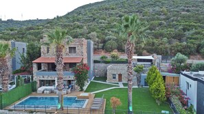A villa with a swimming pool, stone walls, and a lush garden. - Mira villa 1 (Torba)