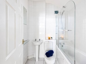 A bathroom with a glass-enclosed shower, a white sink, and a toilet. - Cozy 1BR in New Town - Steps from the Royal Mile (Edinburgh)