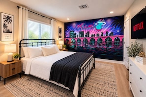 A hotel room with a bed, a nightstand, a lamp, a wall mural of Miami, and a Netflix sign. - NEW! Modern Coastal 5BR, Sunset Villa Near Beach (Pompano Beach)