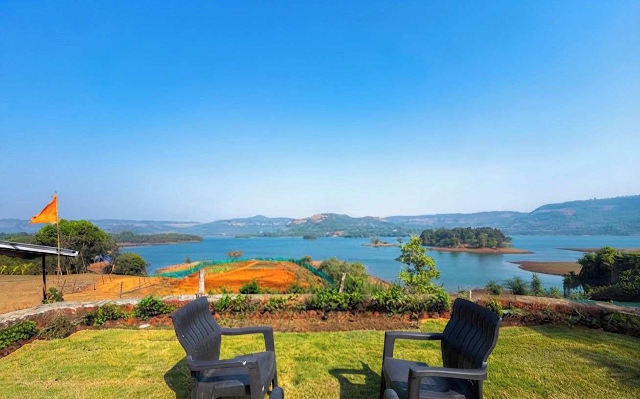 Une terrasse avec deux chaises donnant sur un lac et des collines.