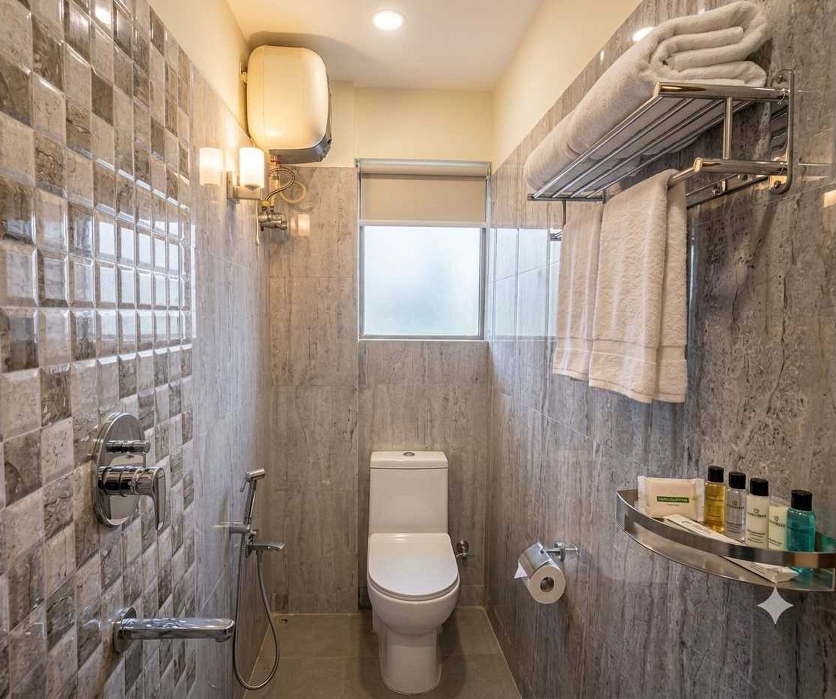 Ein Badezimmer mit Toilette, Dusche und Handtuchhalter.