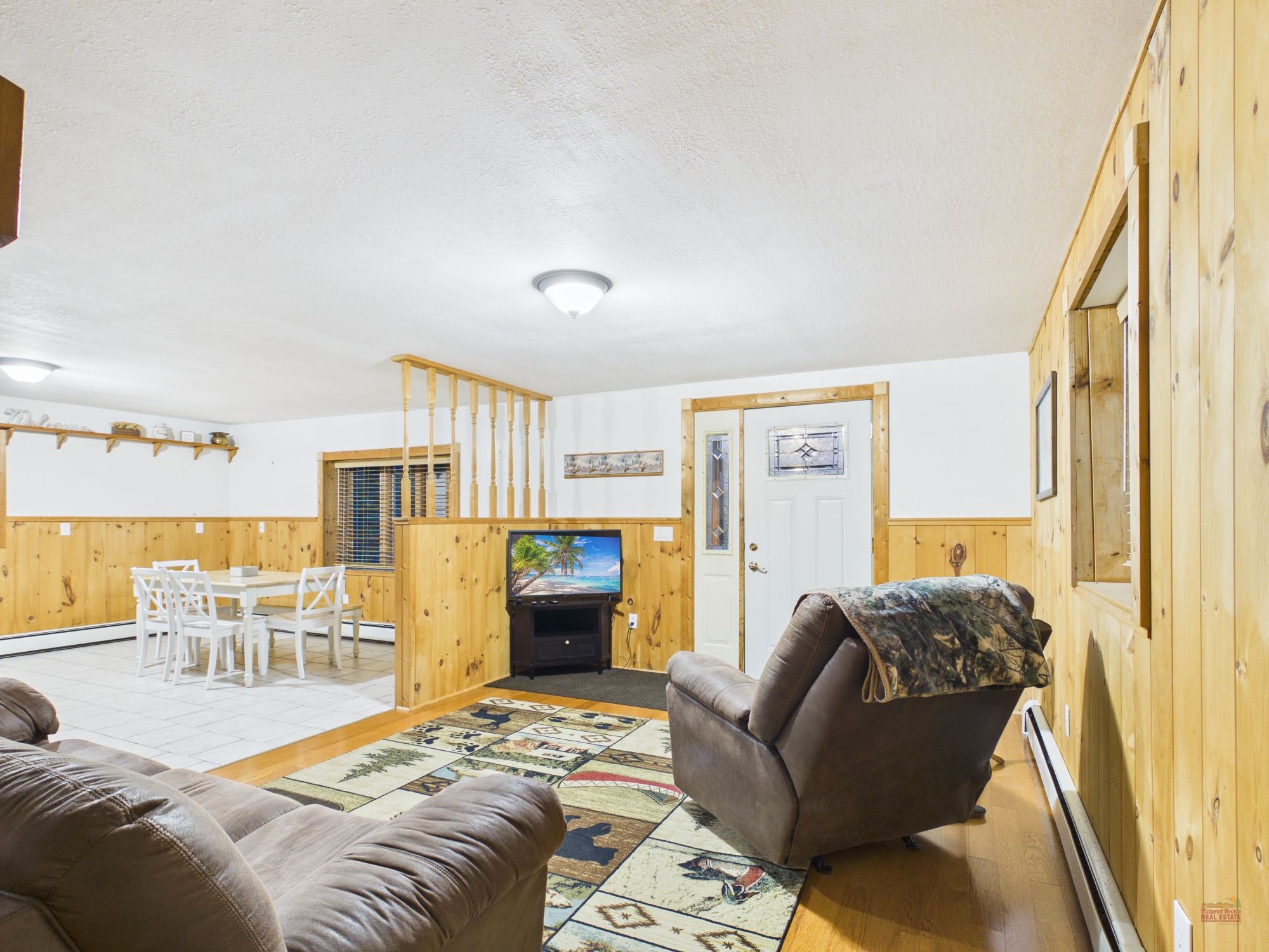 Una sala de estar amoblada con sofá, sillón y televisor.