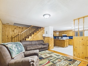 Un intérieur en bois avec un escalier, un canapé et un coin cuisine.