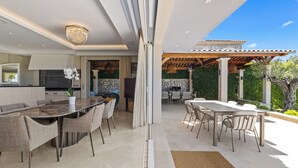 A modern kitchen with a marble countertop and a dining area with a large table and chairs. - Melinda - Super Cannes (Vallauris)