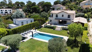 A residential property with a swimming pool, a covered patio, and a well-maintained garden. - Melinda - Super Cannes (Vallauris)
