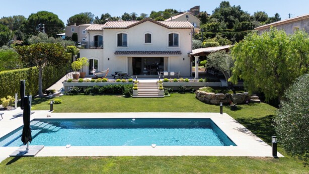 A two-story house with a swimming pool, surrounded by a well-maintained garden and a stone wall. - Melinda - Super Cannes (Vallauris)