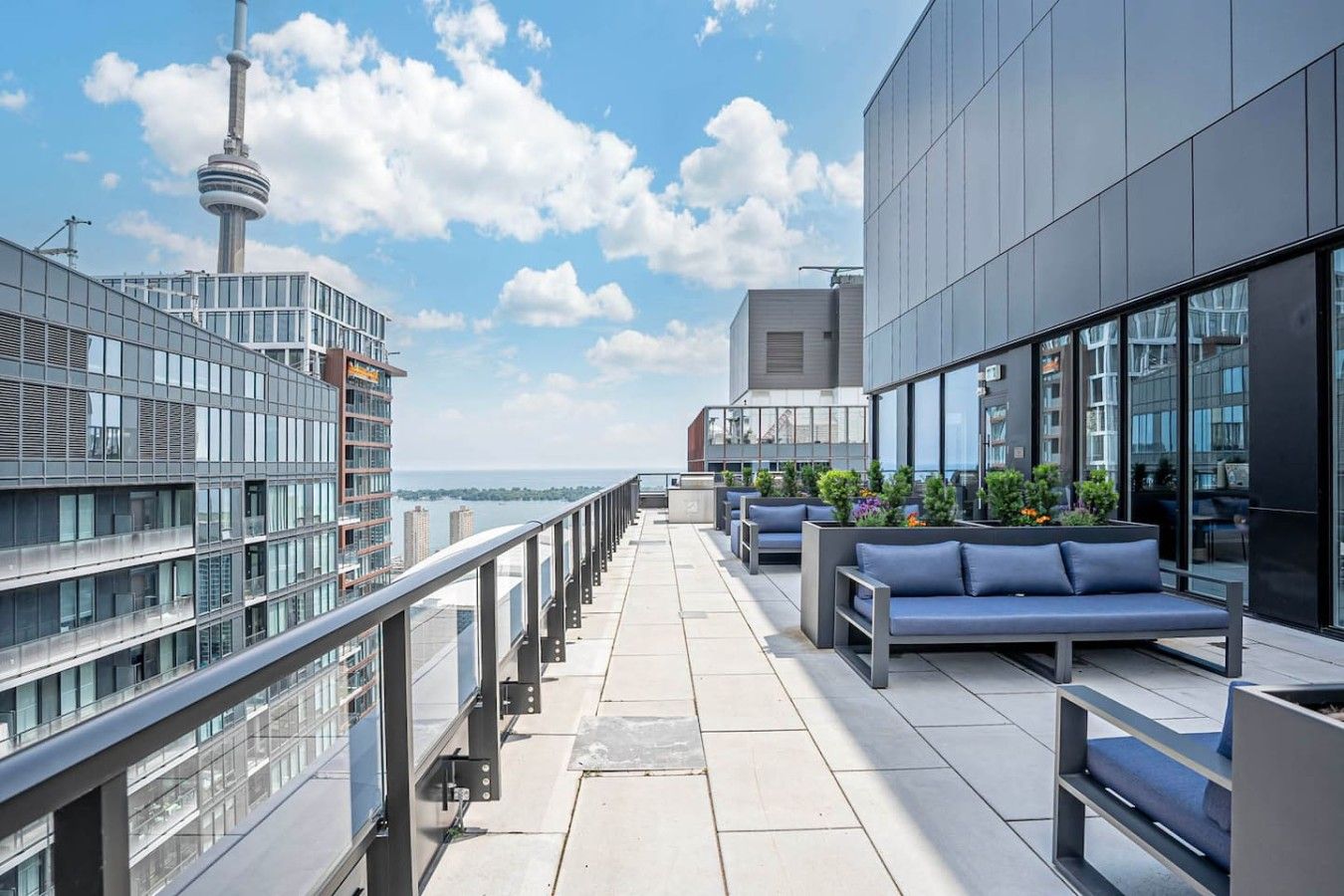 A rooftop terrace with seating and a view of the city skyline, including a tower.