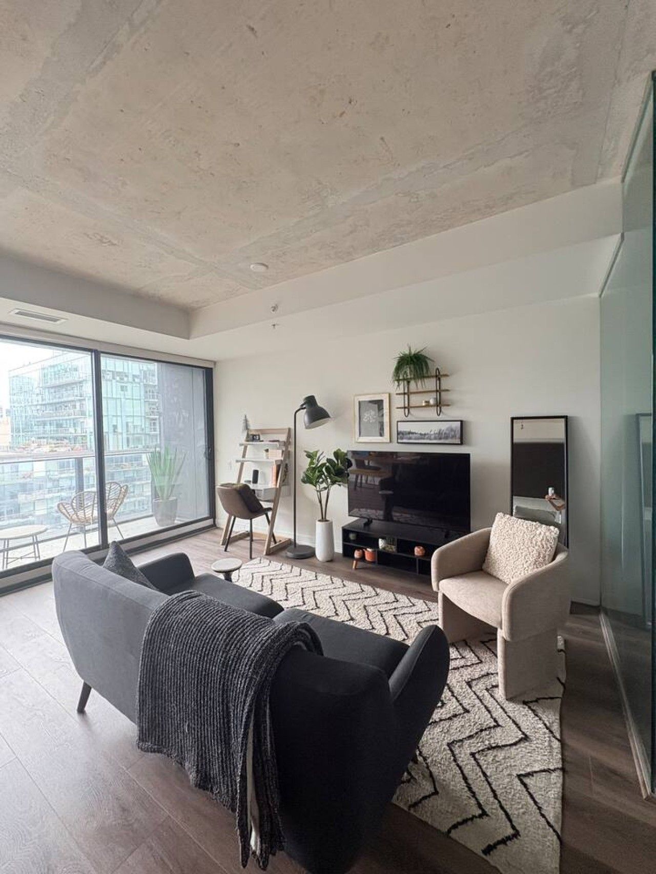 Een moderne woonkamer met een bank, fauteuil en een tv-meubel.