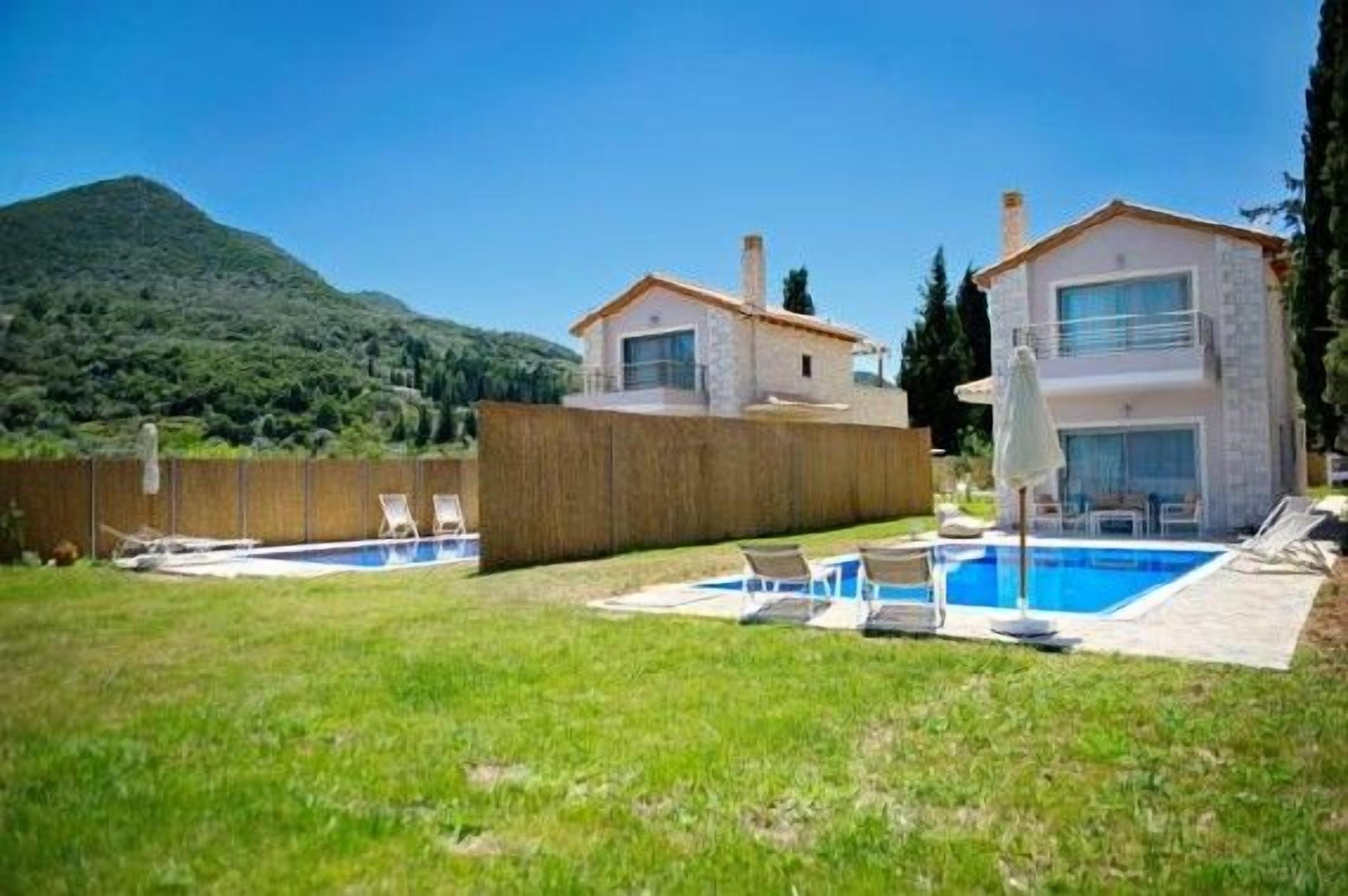 A two-story house with a swimming pool, a covered patio, and a mountain backdrop.