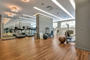 Ein modernes Fitnessstudio mit Laufbändern, Crosstrainern und Kurzhanteln.