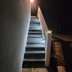 A set of stairs with a handrail and a light fixture at the top. - Guest house on the lake. Trailer parking available (Deltona)