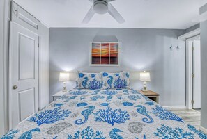A bedroom with a bed, two bedside lamps, a ceiling fan, and a wall-mounted picture. - Royal Garden Resort 812 - Two Bedroom, Two Bath Oceanfront Condo (Garden City Beach)