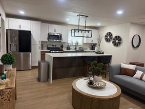 Een moderne keuken met witte kasten, roestvrijstalen apparatuur en een centraal eiland.