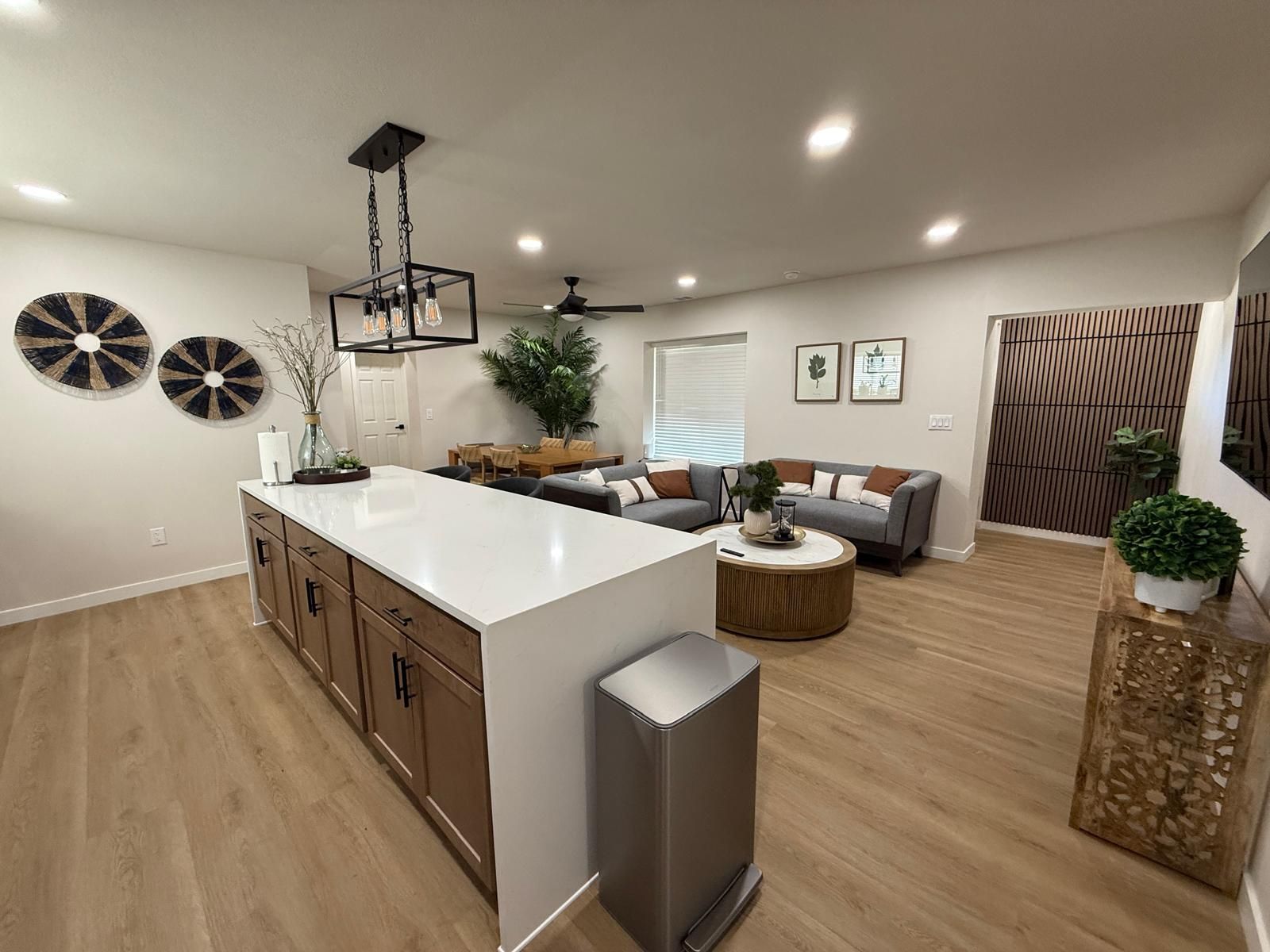 A spacious living area with a central island, a dining table, and a seating arrangement.