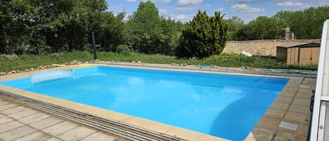 Una piscina rectangular con un borde de baldosas a su alrededor.