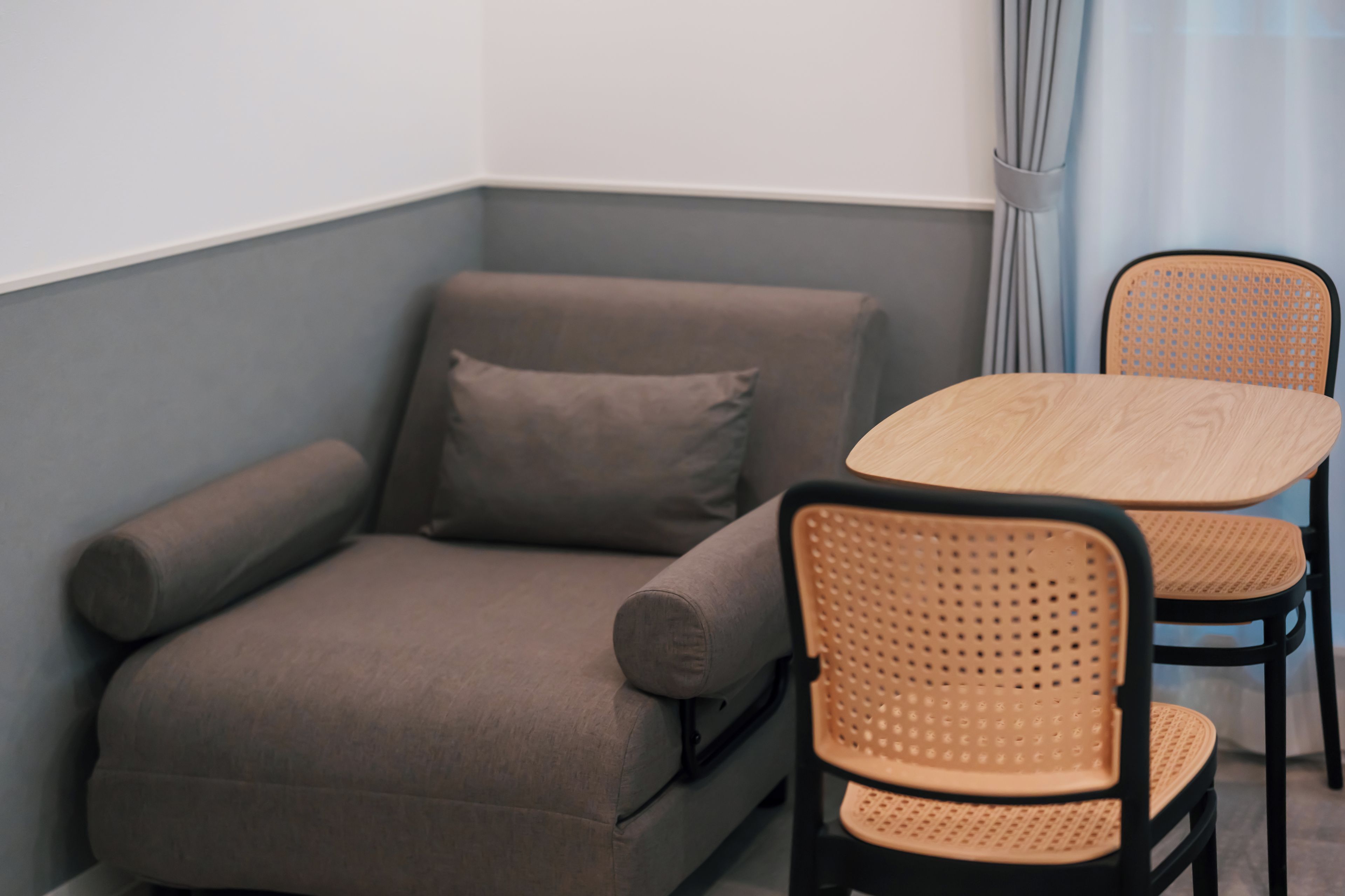 A corner room with a sofa, two chairs, and a small table.