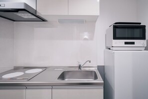 A modern kitchen with stainless steel appliances, a sink, and a microwave. - Ocean Blue 9 (Osaka)