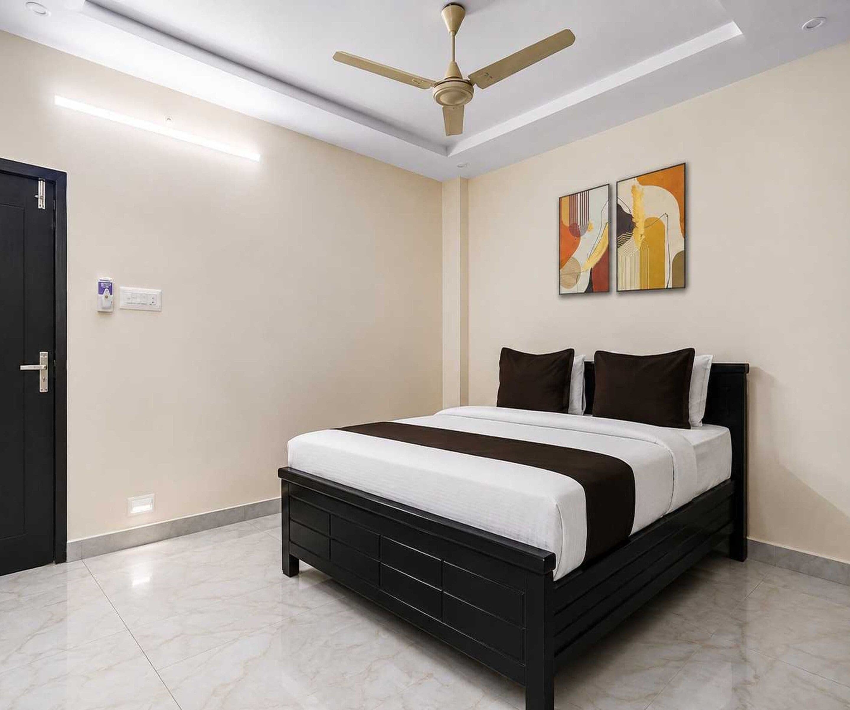A bedroom with a bed, a ceiling fan, and a door.
