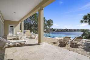 A covered outdoor area with a pool, lounge chairs, and a view of a body of water. - Luxury | Rooftop Gulf Views | Private Pool-Spa | 4 King Bedrooms | Sleeps 14 (Destin)