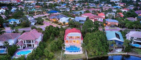 A residential area with houses, a swimming pool, and a waterfront.