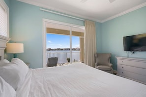 A hotel room with a large bed, a television, a chair, and a view of the outdoors. - Luxury | Rooftop Gulf Views | Private Pool-Spa | 4 King Bedrooms | Sleeps 14 (Destin)