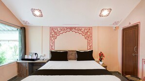 A hotel room with a bed, bedside table, and a window with a view. - Classic Padmavati Lake Resort (Chittorgarh)