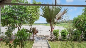 A covered walkway with a view of a water body and surrounding greenery. - Classic Padmavati Lake Resort (Chittorgarh)