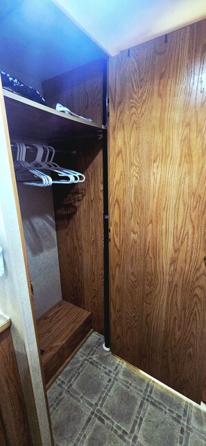 A room with a wooden wardrobe, a metal shelf, and a tiled floor. - Serene 1-bedroom, 1-bathroom, 5th wheel with AC, farms next-door near Lucedale. (Lucedale)