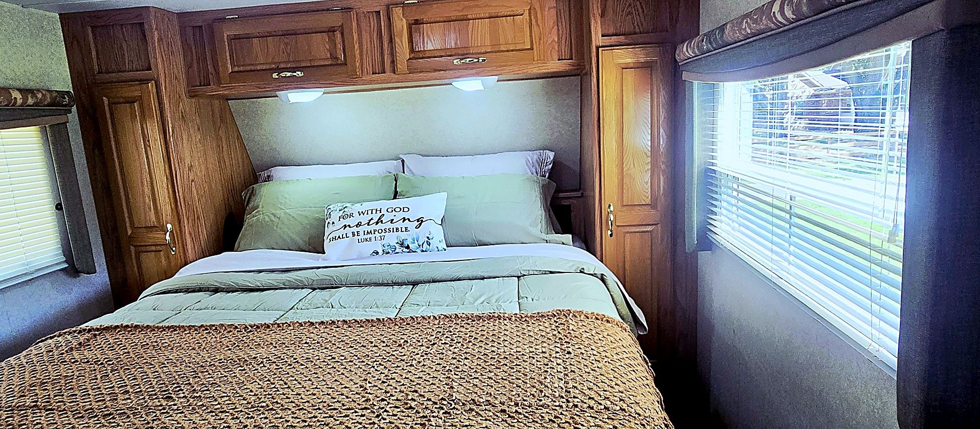Une chambre à coucher avec un lit, des armoires en bois et une fenêtre avec des stores.