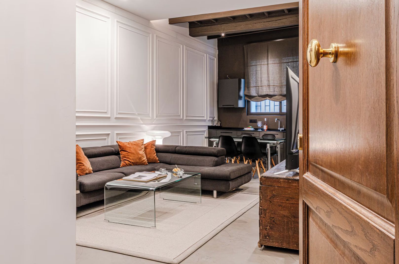 A modern living room with a sofa, coffee table, and a wooden cabinet.
