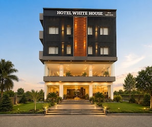 A multi-story hotel with a prominent entrance, large windows, and a well-lit facade.