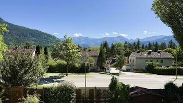 Ein Wohngebiet mit Häusern, einer asphaltierten Straße und einem Berg im Hintergrund.