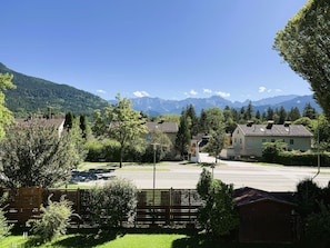 Un quartier résidentiel avec des maisons, une route asphaltée et une chaîne de montagnes en arrière-plan.