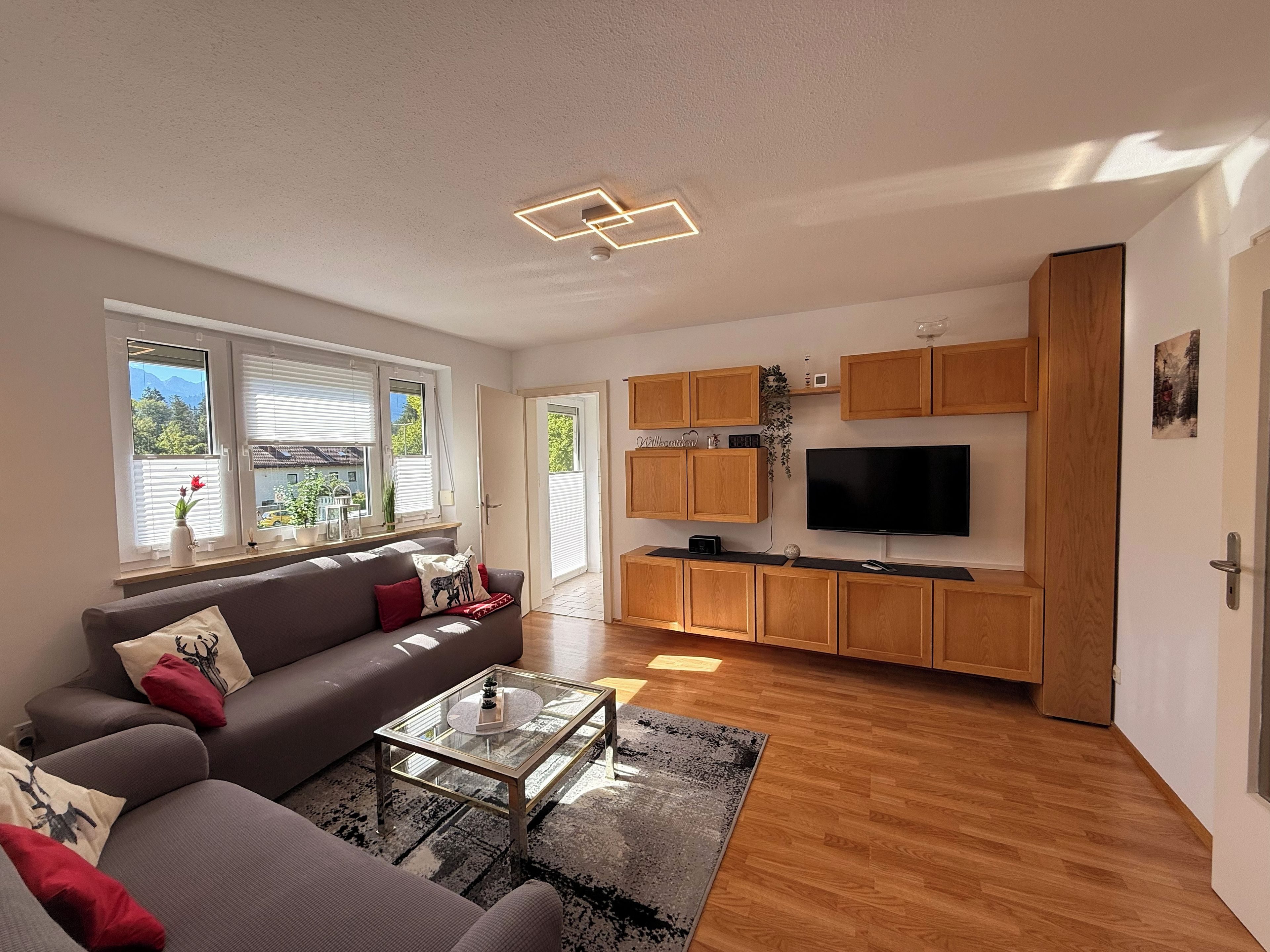 A modern living room with a sofa, coffee table, and a flat-screen TV.