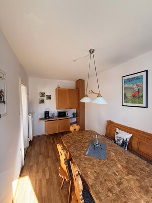 Una cocina funcional con armarios de madera, microondas y cafetera.