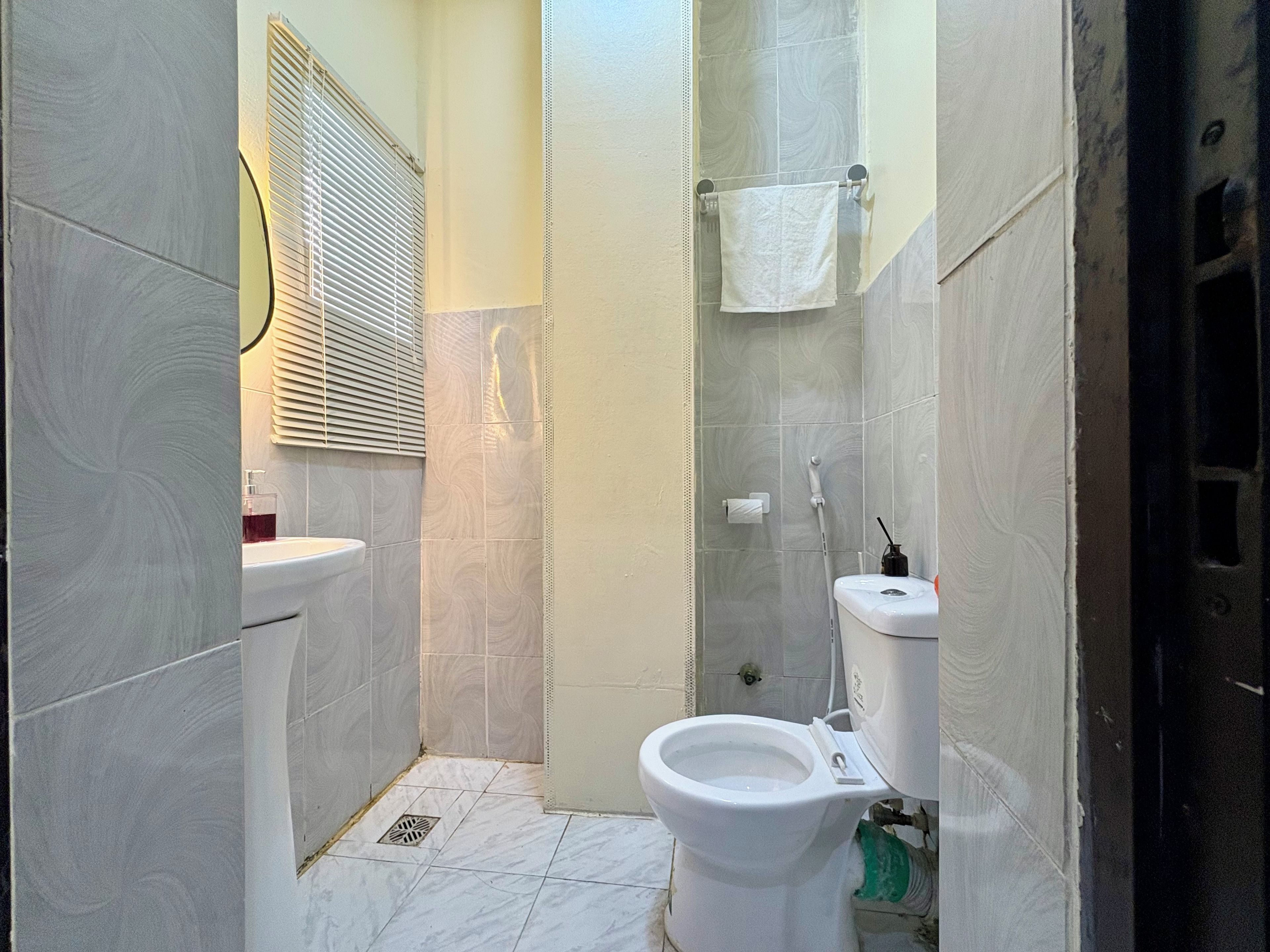 A compact bathroom with a toilet, sink, and shower area.