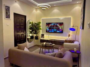 Un saló modern amb televisió de pantalla plana, sofà, taula de centre i una planta en test.