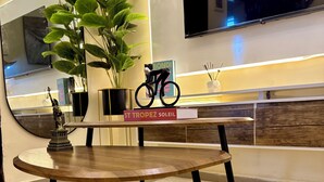 A round wooden table with a book titled 'ST TROPEZ SOLEIL' and a small statue. - Haven 21;  Luxury 1-Bedroom Serviced Apartment in Ajah (Close)